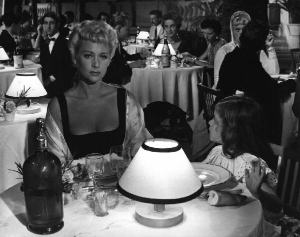 Scena del film "La spiaggia" - Regia Alberto Lattuada - 1953 - L'attrice Martine Carol a tavola con una bambina al ristorante