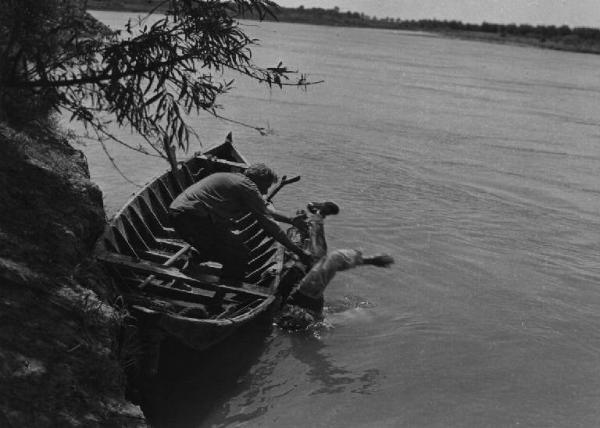 Scena del film "Il mulino del Po" - Regia Alberto Lattuada - 1948 - L'attore Giulio Cali su una barca getta nel fiume l'attore Jacques Sernas