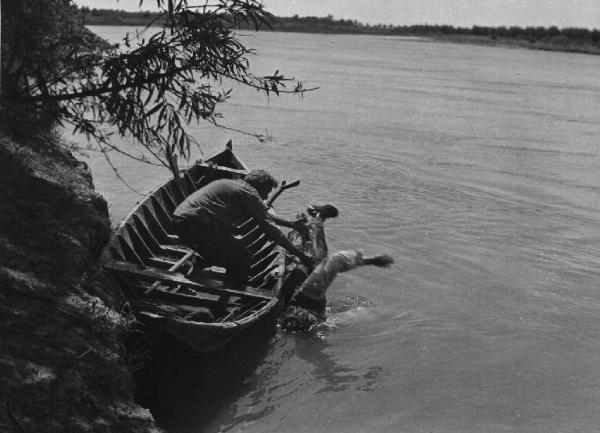 Scena del film "Il mulino del Po" - Regia Alberto Lattuada - 1948 - L'attore Giulio Cali su una barca getta nel fiume l'attore Jacques Sernas