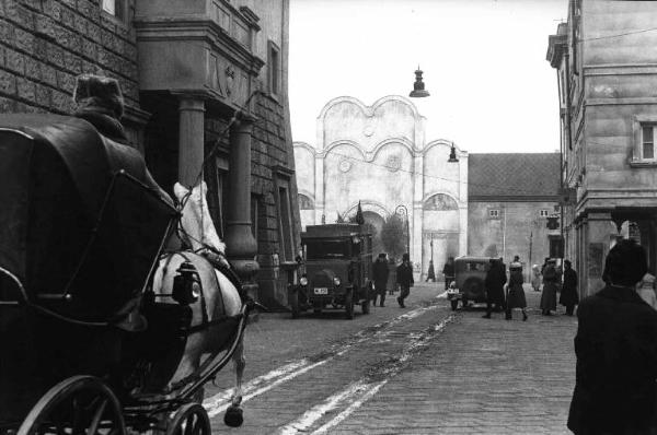 Scena del film "Cuore di cane" - Regia Alberto Lattuada - 1976 - Una carrozza trainata da un cavallo percorre una strada che conduce a una grande piazza