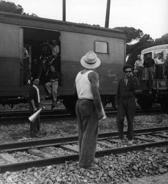 Set del film "Senza pietà" - Regia Alberto Lattuada - 1948 - Il regista Alberto Lattuada con attore non identificati e gli operatori della trupe su un treno