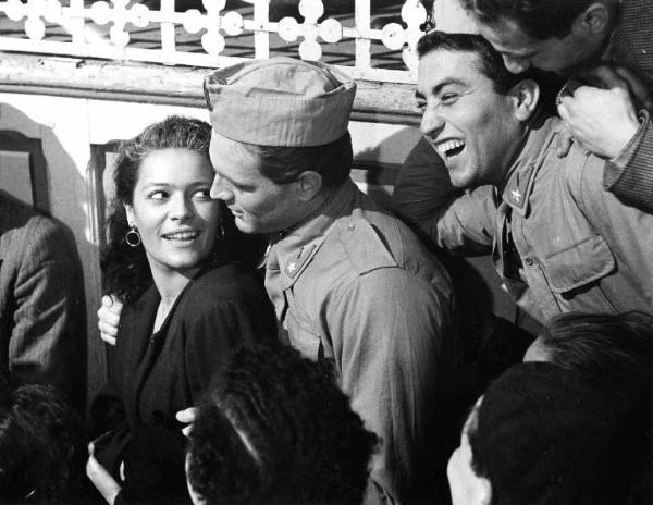 Scena del film "La lupa" - Regia Alberto Lattuada - 1953 - Gli attori Ettore Manni, in divisa militare, e Kerima tra la folla