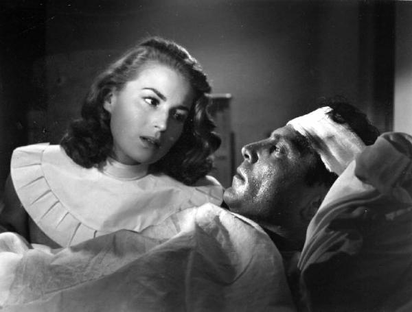 Scena del film "Anna" - Regia Alberto Lattuada - 1951 - L'attrice Silvana Mangano, in veste di suora infermiera, assiste Raf Vallone malato a letto