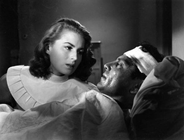 Scena del film "Anna" - Regia Alberto Lattuada - 1951 - L'attrice Silvana Mangano, in veste di suora infermiera, in lacrime assiste Raf Vallone malato a letto