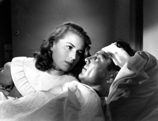 Scena del film "Anna" - Regia Alberto Lattuada - 1951 - L'attrice Silvana Mangano, in veste di suora infermiera, in lacrime assiste Raf Vallone malato a letto