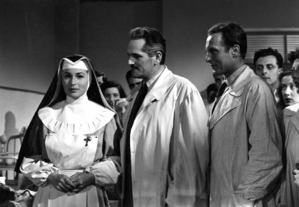 Scena del film "Anna" - Regia Alberto Lattuada - 1951 - L'attrice Silvana Mangano, in veste di suora infermiera, con gli attori Jacques Dumesnil, Piero Lulli, in camice bianco in ospedale