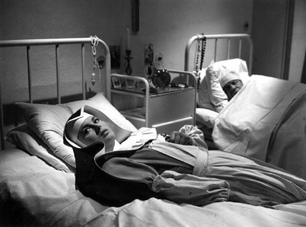 Scena del film "Anna" - Regia Alberto Lattuada - 1951 - L'attrice Silvana Mangano in abito da suora infermiera sdraiata su un letto in ospedale