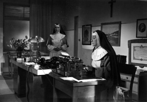 Scena del film "Anna" - Regia Alberto Lattuada - 1951 - Le attrici Silvana Mangano, in abito da suora infermiera, e Gaby Morlay, in veste di madre superiora seduta a una scrivania