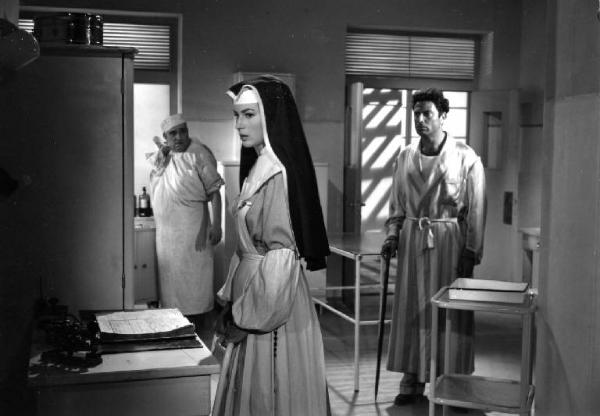 Scena del film "Anna" - Regia Alberto Lattuada - 1951 - Gli attori Silvana Mangano, in abito da suora infermiera, Raf Vallone, in vestaglia, e Paolo Ferrara, infermiere