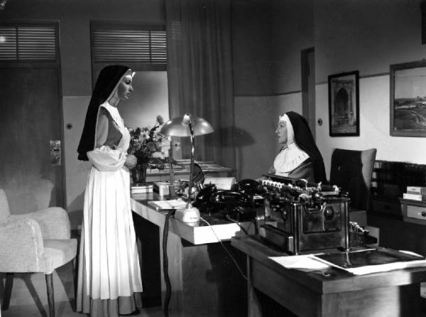 Scena del film "Anna" - Regia Alberto Lattuada - 1951 - Le attrici Silvana Mangano, in abito da suora infermiera, e Gaby Morlay, in veste di madre superiora seduta a una scrivania