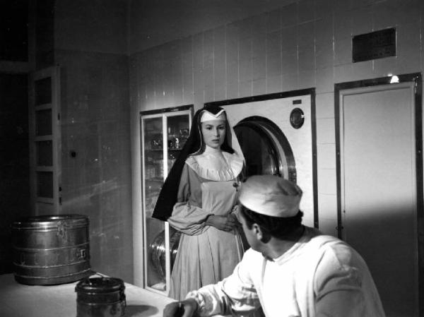 Scena del film "Anna" - Regia Alberto Lattuada - 1951 - L'attrice Silvana Mangano in abito da suora infermiera e un attore non identificato di spalle