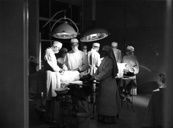 Scena del film "Anna" - Regia Alberto Lattuada - 1951 - L'attore Piero Lulli in camice bianco in sala operatoria con attori non identificati