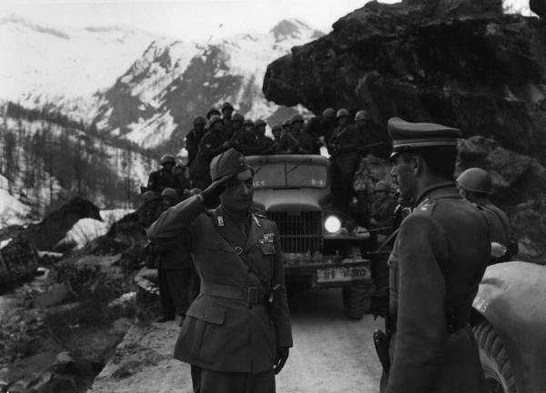 Scena del film "Il bandito" - Regia Alberto Lattuada - 1946 - Due attori non identificati in divisa militare e un gruppo di soldati su una camionetta