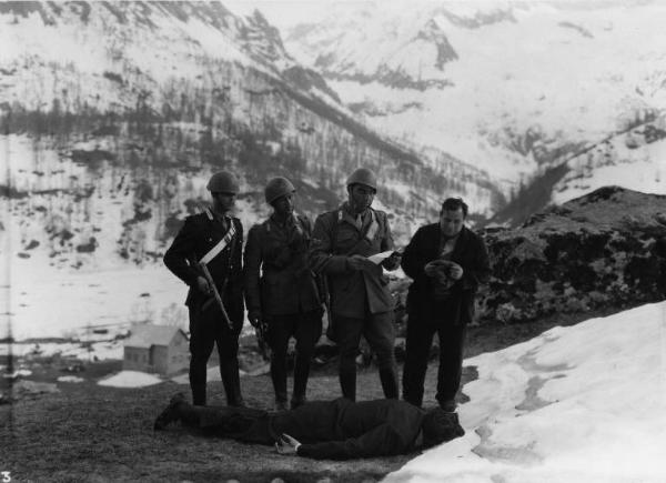 Scena del film "Il bandito" - Regia Alberto Lattuada - 1946 - L'attore Carlo Campanini e tre attori in divisa militare davanti a un uomo steso a terra