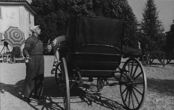 Scena del film "Giacomo l'idealista" - Regia Alberto Lattuada - 1943 - Un operatore della troupe accanto a una carrozza