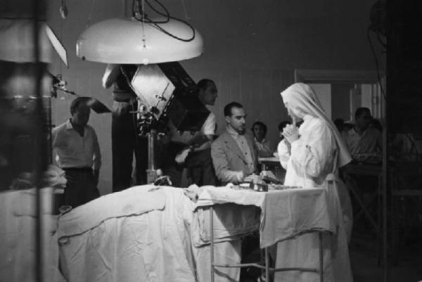 Set del film "Anna" - Regia Alberto Lattuada - 1951 - L'attrice Silvana Mangano in abito da suora infermiera con il regista Alberto Lattuada sul set con gli operatori della troupe