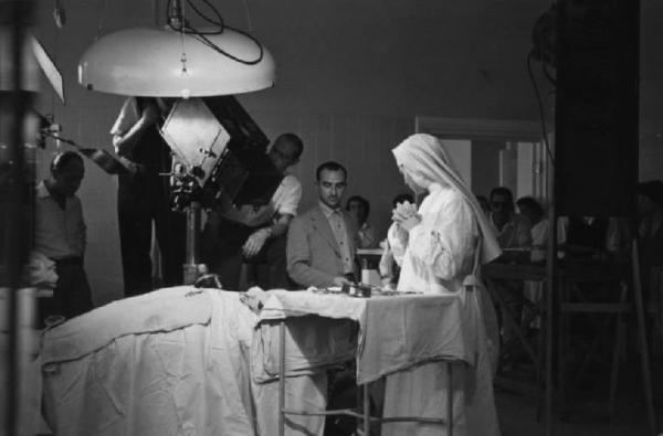 Set del film "Anna" - Regia Alberto Lattuada - 1951 - L'attrice Silvana Mangano in abito da suora infermiera con il regista Alberto Lattuada sul set con gli operatori della troupe