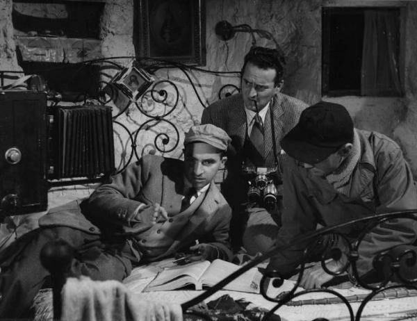 Set del film "La lupa" - Regia Alberto Lattuada - 1953 - Il regista Alberto Lattuada sul set con il fotografo Federico Patellani e un operatore della troupe su un letto