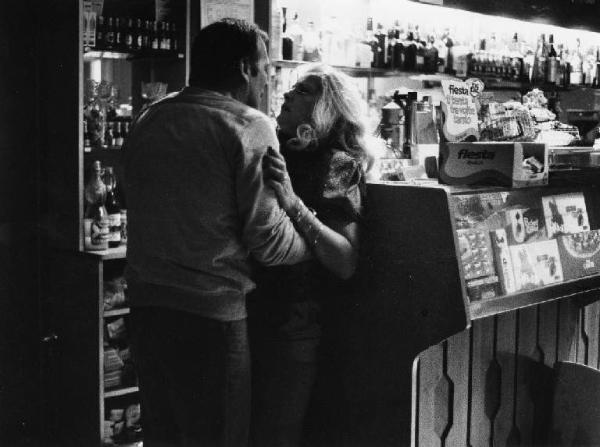 Scena del film "La cicala" - Regia Alberto Lattuada - 1980 - Gli attori Renato Salvatori e Virna Lisi abbracciati in un bar