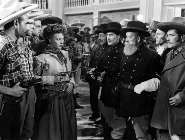 Scena del film "Adamo ed Eva" - Regia Mario Mattoli - 1949 - L'attrice Isa Barzizza e attori non identificati vestiti da cow-boy e da ufficiali tutti armati di pistola