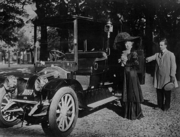 Scena del film "Addio giovinezza" - Regia Ferdinando Maria Poggioli - 1940 - Un autista apre la portiera dell'automobile per consentirne l'ingresso all'attrice Clara Calamai