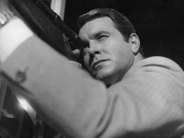 Scena del film "L'affare Beckett" - Regia Osvaldo Civirani - 1966 - Un attore non identificato guarda nel mirino di un fucile
