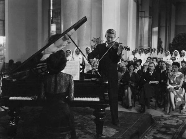 Scena del film "Amanti senza amore" - Regia Gianni Franciolini - 1947 - Gli attori Clara Calamai, al pianoforte, e Jean Servais, al violino, suonano davanti al pubblico