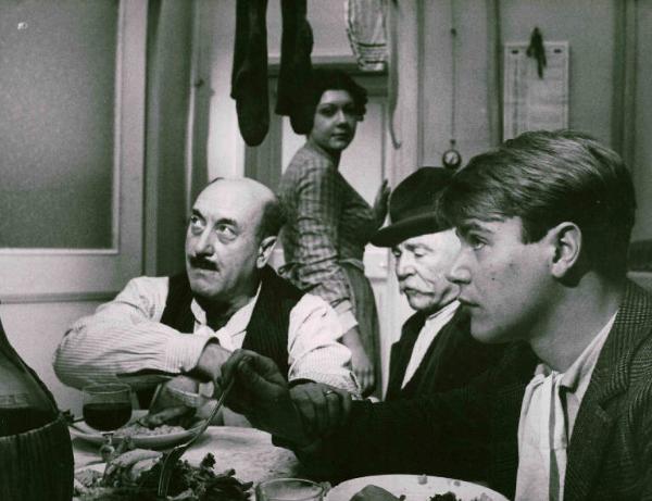 Scena del film "Amarcord" - Regia Federico Fellini - 1973 - Gli attori Armando Brancia, Giuseppe Ianigro e Bruno Zanin a tavola. Dietro di loro l'attrice Carla Mora