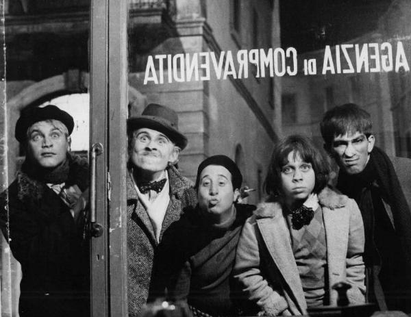 Scena del film "Amarcord" - Regia Federico Fellini - 1973 - Gli attori Bruno Zanin, Alvaro Vitali e tre attori non identificati attaccati a una vetrina