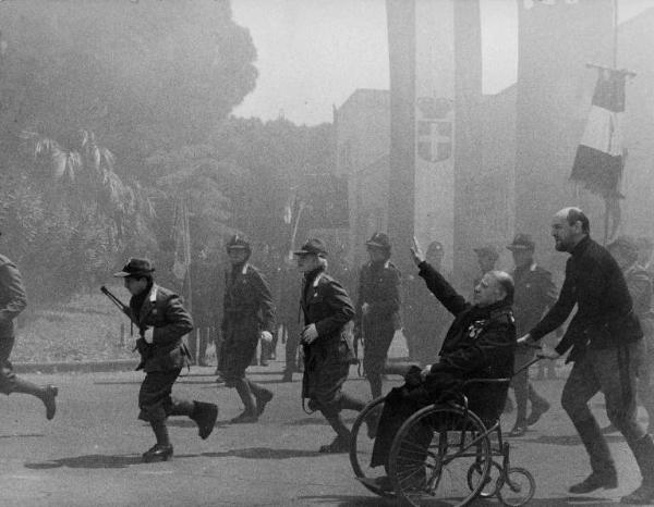 Scena del film "Amarcord" - Regia Federico Fellini - 1973 - L'attore Alvaro Vitali e attori non identificati in camicia nera e divise da ufficiali fascisti