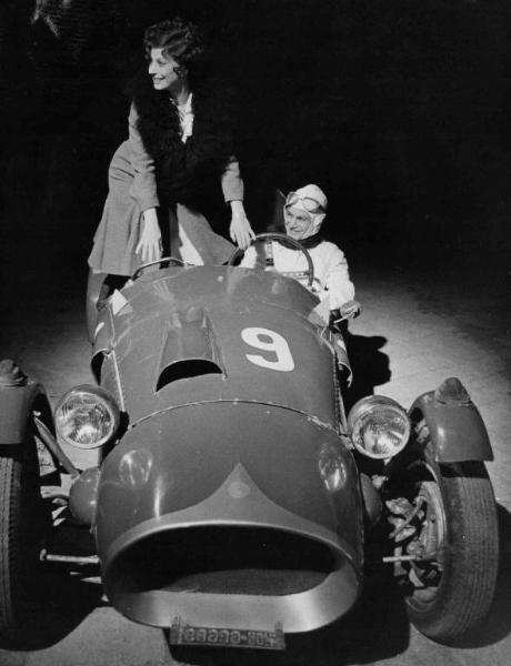 Scena del film "Amarcord" - Regia Federico Fellini - 1973 - Due attori non identificati a bosrdo di una macchina da corsa