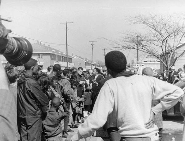 Scena del film documentario "America paese di Dio" - Regia Luigi Vanzi - 1966 - Gruppo di manifestanti con cartelli davanti a poliziotti