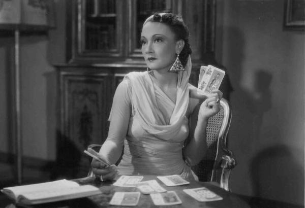 Scena del film "Amicizia" - Regia Oreste Biancoli - 1938 - L'attrice Elsa Merlini al tavolo con le carte dei tarocchi