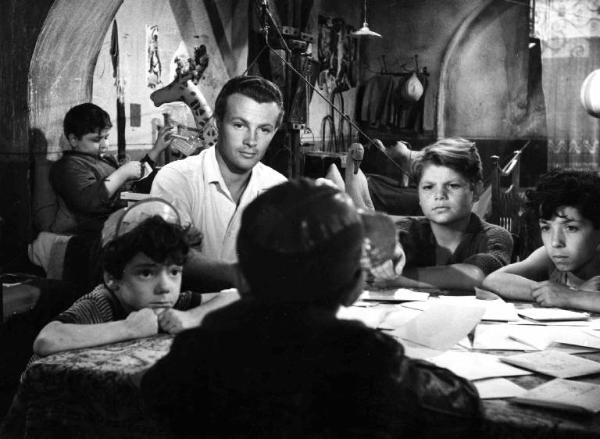 Scena del film "Gli angeli del quartiere" - Regia Carlo Borghesio - 1952 - L'attore Jacques Sernas con Giancarlo Nicotra e altri bambini