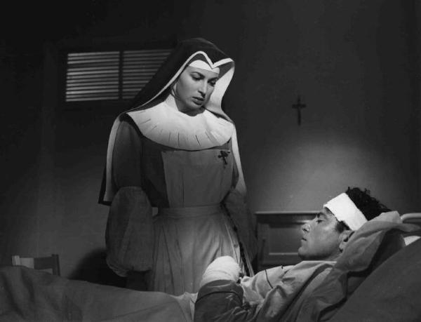 Scena del film "Anna" - Regia Alberto Lattuada - 1951 - L'attrice Silvana Mangano, in abito da suora infermiera, osserva l'attore Raf Vallone ferito nel letto di un ospedale