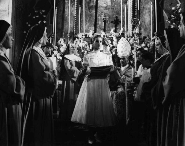 Scena del film "Anna" - Regia Alberto Lattuada - 1951 - L'attrice Gaby Morlay, in abito da suora in chiesa in un gruppo di preti e suore, osserva l'attrice Silvana Mangano al centro