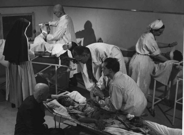 Scena del film "Anna" - Regia Alberto Lattuada - 1951 - L'attore Jacques Dumesnil, in camice bianco, insieme ad attori non identificati in abito da infermieri curano i pazienti in ospedale