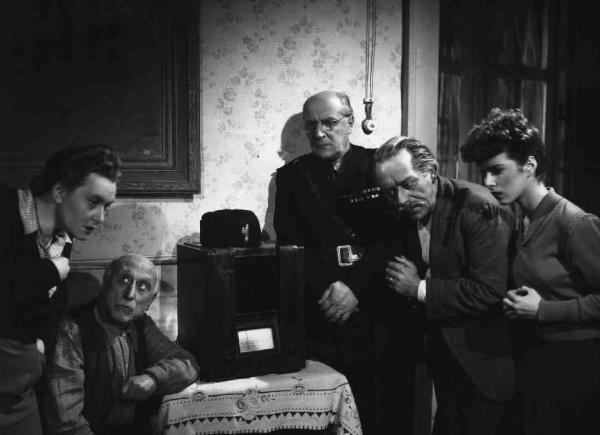 Scena del film "Anni difficili" - Regia Luigi Zampa - 1948 - Gli attori Ave Ninchi, Ernesto Almirante, Umberto Spadaro, Delia Scala e un attore non identificato in divisa da camerata fascista accanto a una radio