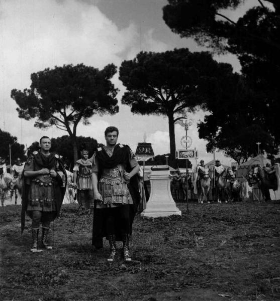 Set del film "Attila" - Regia Pietro Francisci - 1954 - Gli attori Henry Vidal e Georges Bréhat in divisa da centurioni romani. Dietro di loro soldati a cavallo