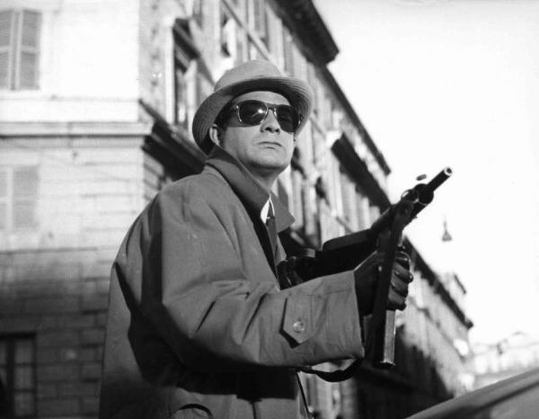 Scena del film "La banda Casaroli" - Regia Florestano Vancini - 1962 - L'attore Jean-Claude Brialy impugna un mitra