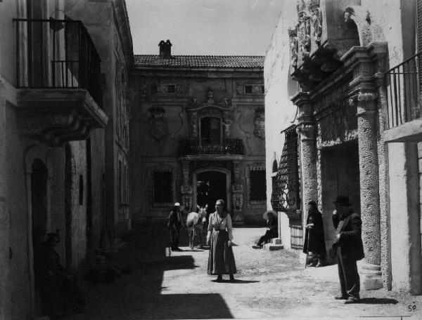 Scena del film "La bella addormentata" - Regia Luigi Chiarini - 1942 - L'attrice Luisa Ferida per le strade del paese tra attori non identificati e un asino