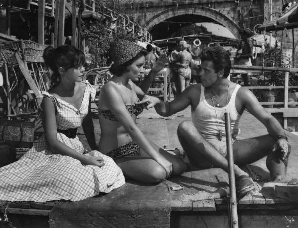 Scena del film "Belle ma povere" - Regia Dino Risi - 1957 - L'attore Renato Salvatori e due attrici non identificate in bikini