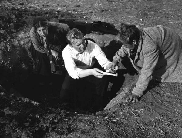 Scena del film "Il bidone" - Federico Fellini - 1955 - L'attore Franco Fabrizi e due attrici non identificate che scavano una buca