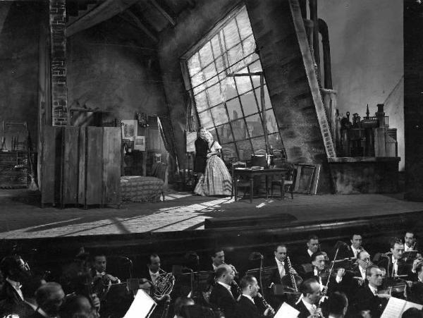 Scena del film "La Bohème" - Marcel L'Herbier - 1942 - L'orchestra e due attori non identificati sul palcoscenico di un teatro