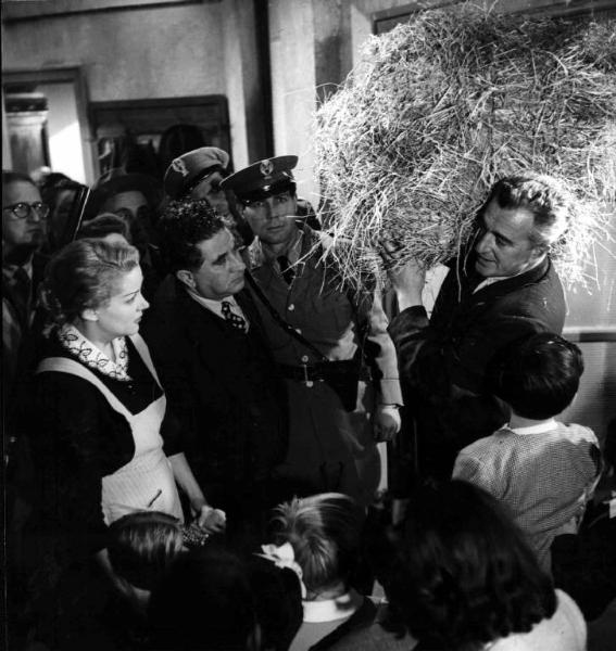 Scena del film "Buongiorno, elefante" - Gianni Franciolini - 1952 - Gli attori Vittorio De Sica, con una balla di paglia sulle spalle, Maria Mercader e attori non identificati