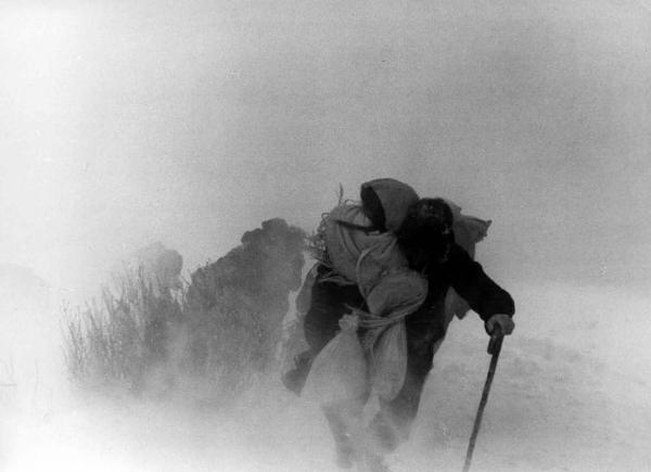 Scena del film "Il cammino della speranza" - Pietro Germi - 1950 - L'attore Raf Vallone con un bambino in braccio in una tempesta di neve