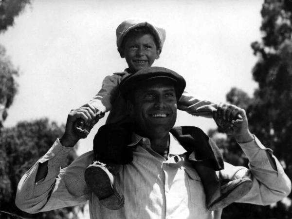 Scena del film "Il cammino della speranza" - Pietro Germi - 1950 - L'attore Raf Vallone e Chicco Coluzzi sulle sue spalle