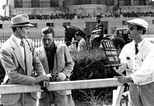 Set del film "Le casa del peccato" - Regia Max Neufeld - 1938 - L'attore Amedeo Nazzari all'ipodromo per le corse dei cavalli con un attore non identificato e un operatore