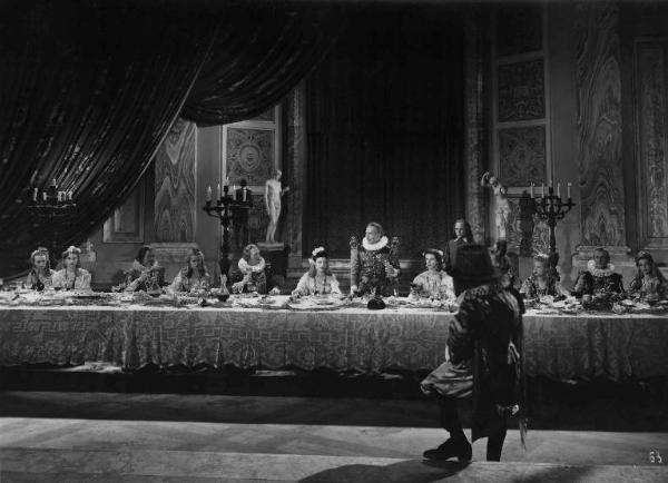 Scena del film "Il cavaliere senza nome" - Regia Ferruccio Cerio - 1941 - L'attore Mario Ferrari a tavola con attori non identificati