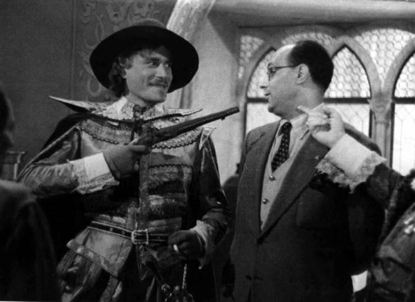 Set del film "Il cavaliere senza nome" - Regia Ferruccio Cerio - 1941 - L'attore Amedeo Nazzari punta una pistola contro il regista Ferruccio Cerio